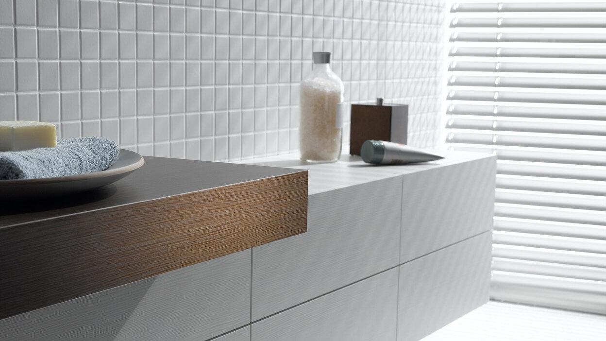 Detailaufnahme eines weißen Waschtischunterschrankes mit dunkler Waschtischplatte