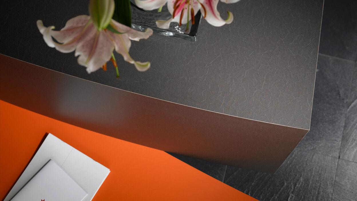 Detailaufnahme einer Empfangstheke mit Kontrast-Lackierung in Schwarz und Orange