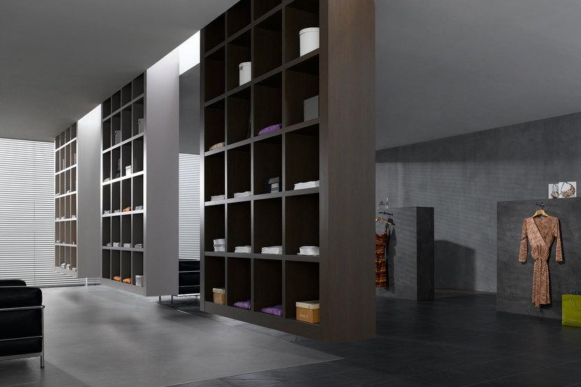 Impression eines geräumigen Regalsystems aus dunklem Holz in einem hochwertigen Bekleidungsladen