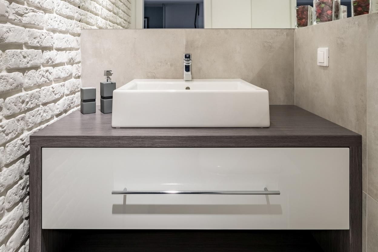 Waschtischunterschrank im Gäste-WC Nischenlösung für Waschtisch im Gäste-WC mit weißer Schublade an Betonwand